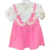 A girls' L-size dress set featuring a white top with a floral print layered under a pink pinafore-style dress with cat-face accents and ruffle trim.