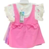 A girls' S-size dress set featuring a white top with fruit patterns and ruffle sleeves, layered under a vibrant pink pinafore dress with two bows at the waist.