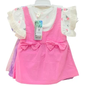 A girls' S-size dress set featuring a white top with fruit patterns and ruffle sleeves, layered under a vibrant pink pinafore dress with two bows at the waist.